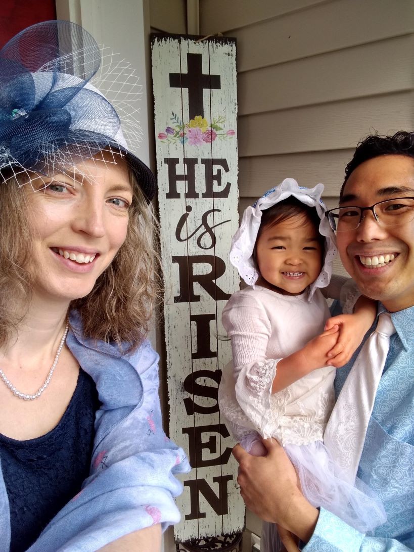 adoptive mom with a pretty Easter bonnet with her husband and daughter on the front porch