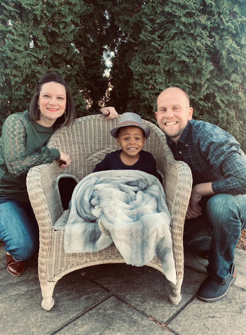Seth and Megan sitting on their front porch with their infant son, ready to adopt in Ohio through Spirit of Faith Adoptions.